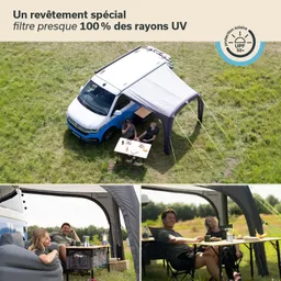 Ein Fahrzeug steht auf einer Wiese unter einem Vorzelt. Zwei Personen sitzen an einem Tisch mit Snacks.