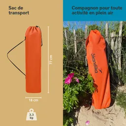 Oranger Transportbeutel mit Maßangaben (77 cm x 18 cm, 3,3 kg) neben Pflanzen und einem Holzlattenzaun.
