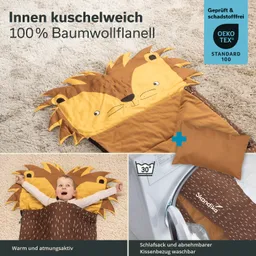 Schlafsack mit Löwenmotiv aus Baumwollflanell, abnehmbarer Kissenbezug und Waschhinweis. Kind liegt darin auf einem Teppich.