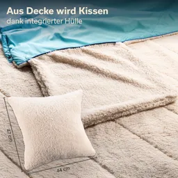 Decke mit integrierter Hülle, beige, samtig. Ein Kissen in gleichem Material und neutrale Maße 44 cm x 47 cm daneben.