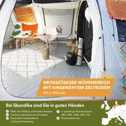 Ein innenliegender Wohnbereich eines Zeltes mit einem Tisch, vielen Stühlen, einer Matte, Taschen und Pflanzen.
