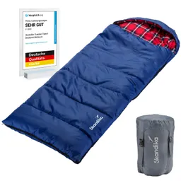 Blaue Schlafsack mit kariertem Innenfutter und Rucksack, daneben ein Preisschild mit der Auszeichnung „Sehr Gut“.