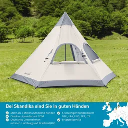 Ein zeltartiges Aufbau mit grauem Dach und weißen Seiten auf einer Wiese, umgeben von Bäumen im Hintergrund.