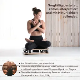 Eine Person sitzt im Schneidersitz auf einem Holzbrett mit Rollen. Der Hintergrund ist hell, mit Holzpaneelen.
