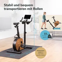 Ein Heimtrainer mit Holzoptik und schwarzem Gestell steht auf einer Bodenschutzmatte. Maße und Produktgewicht sind angegeben.