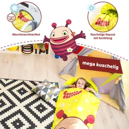 Ein Kind liegt in einem bunten Schlafsack auf dem Boden. Umgeben von einem teppichartigen Muster, einem Kissen und einem Zelt aus buntem Stoff.