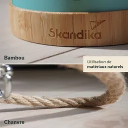 Ein Holzstandfuß aus Bambus mit der gravierten Aufschrift „Skandika“ und ein Hanfseil auf einer hellen Holzoberfläche.
