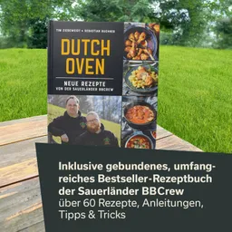 Rezeptbuch mit dem Titel "Dutch Oven", umgeben von grüner Wiese. Cover zeigt zwei Personen und verschiedene Gerichte in Töpfen.
