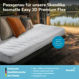 Eine Schlafmatte auf einem Bett in einem Fahrzeug. Kissen in verschiedenen Farben sind platziert. Naturlandschaft sichtbar.