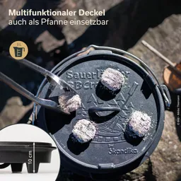 Ein schwarzer, runder Deckel mit einem Griff und mehreren Grillkohle-Stücken darauf, neben einem kleinen, quadratischen Bild mit Maßangabe.
