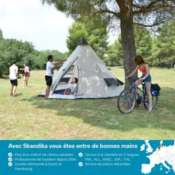 Eine Gruppe von Personen ist im Freien. Ein Zelt steht auf einer Wiese, während eine Person das Zelt aufbaut. Eine weitere Person sitzt im Zelt, und eine dritte Person mit einem Fahrrad steht in der Nähe eines Baumes.