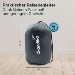 Dunkelgrauer, runder Reisestoffbeutel mit Zugband, Markenname "Skandika" auf der Vorderseite. Maße: 30 cm hoch, 16 cm Durchmesser.