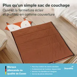 Eine orangefarbene Decke mit einem Fuchsdesign am Kopfbereich liegt auf einem Holzboden.