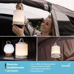 Eine Person hält eine tragbare Lampe in der Hand, während sie diese an einem Zelt befestigt. Im Bild sind zwei weitere Lampen, eine in runder Form, sichtbar. Der Hintergrund zeigt Zelte und einen Werbebereich mit Informationen über die Marke Skandika.