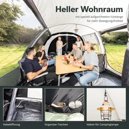 Zeltinneres mit Tisch und Stühlen, sechs Personen sitzen und essen, Vorhängelampe und Organizer-Taschen sichtbar.