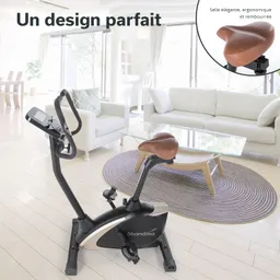 Fitnessbike mit braunem Sitz in einem hellen Raum. Im Hintergrund Sofa und Tisch, heller Boden und Fenster.