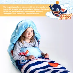 Mädchen mit grauem Langarmshirt sitzt in einem blauen Schlafsack mit gestreiftem Design. Der Schlafsack hat eine Kapuze.