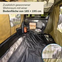 Innenraum eines Vorzeltes, ausgestattet mit einem Tisch, Rucksäcken und einer Picknickdecke. Zweisichtige Fenster sichtbar.