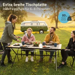 Ein Tisch mit extrabreiter Tischplatte steht auf einer Wiese. Vier Personen sitzen ringsum und essen. Im Hintergrund steht ein grüner VW-Bus. Maße des Tisches sind angegeben.