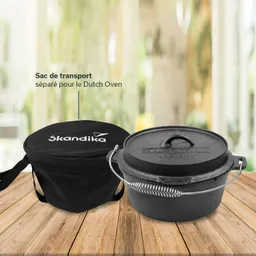 Schwarze Tragetasche mit Aufschrift „Skandika“ links, daneben ein gusseiserner Dutch Oven mit Henkel auf Holzuntergrund.