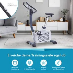 Ein Heimtrainer steht in einem modernen Wohnraum. Im Hintergrund sind ein Sofa, ein Teppich und Möbel zu sehen.