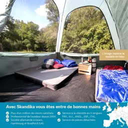 Zeltinneres mit Matratze, Schlafsäcken und Kissen auf dem Boden. Außenbereich im Hintergrund mit Bäumen.