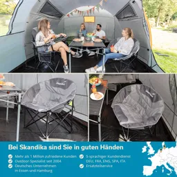 Im Zelt sitzen vier Personen um einen Tisch. Auf dem Tisch stehen Essen und Getränke. Es gibt gemütliche, graue Faltstühle. Bunte Girlanden sind an der Zeltdecke befestigt.