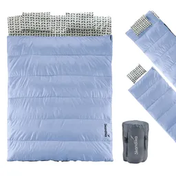 Eine blaue Schlafsäcke mit gestreiften Kissenbezügen und einem grauen Packsack.