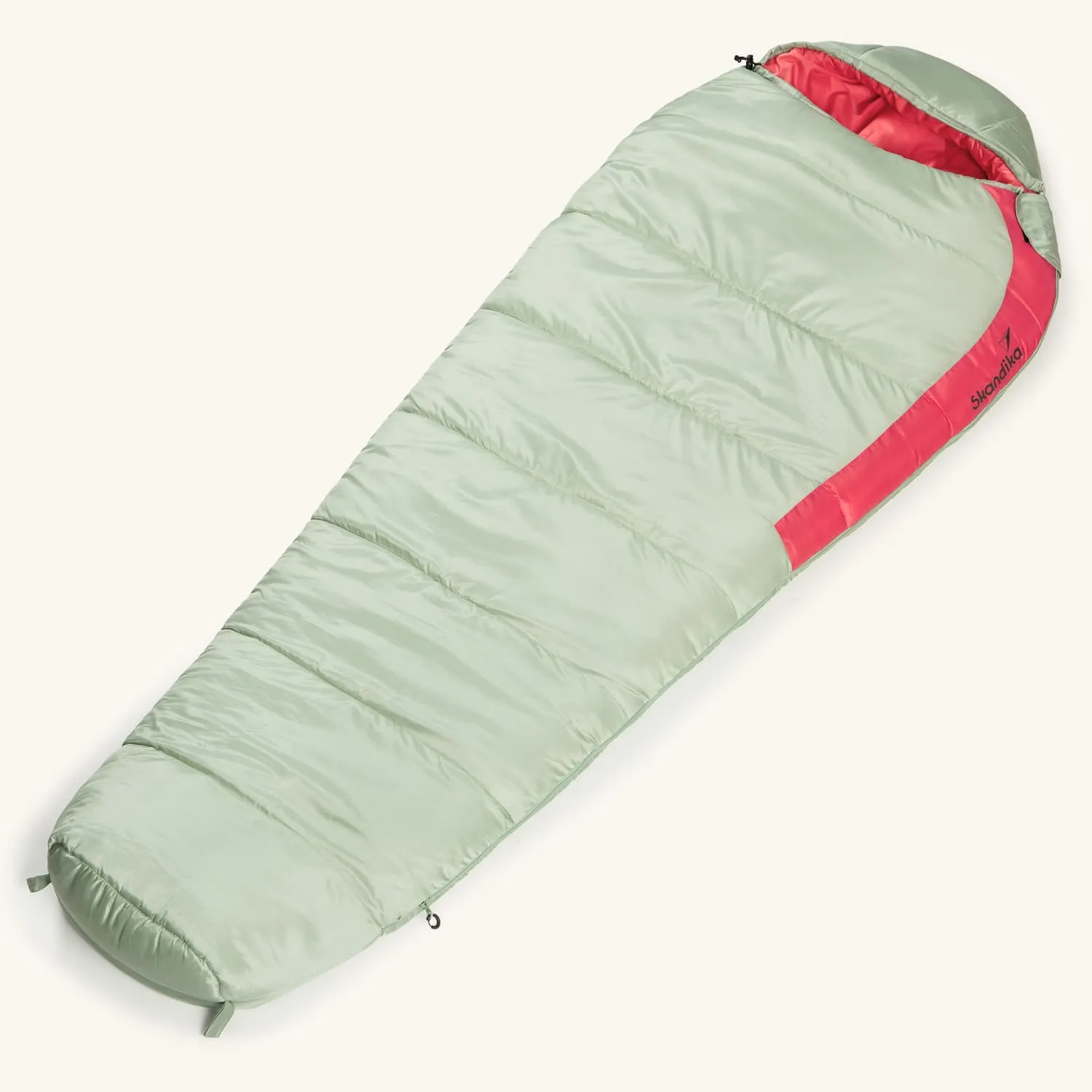 Grüner Schlafsack mit roten Akzenten, länglich und leicht gepolstert, im oberen Bereich leicht geöffnet.