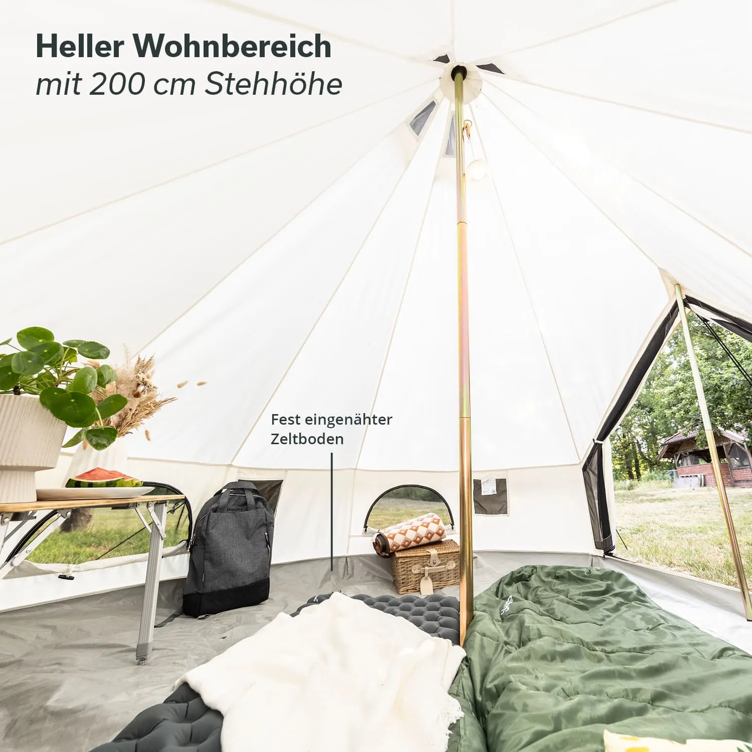 Heller Innenraum eines Zeltes mit 200 cm Stehhöhe. Ausgestattet mit einem Tisch, Pflanzen, Schlafsäcken und einem festen Zeltboden.