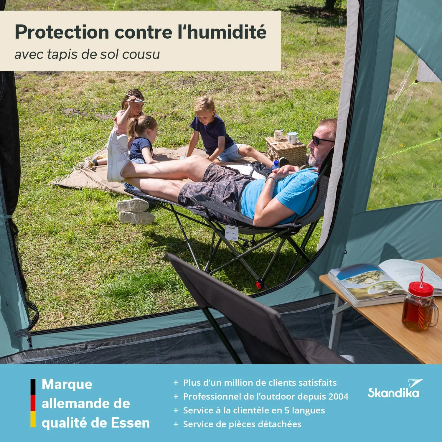 Familie im Freien, eine Person liegt entspannt auf einem Stuhl, während Kinder auf dem Boden spielen. Im Hintergrund sind Pflanzen sichtbar, ein Tisch mit Getränk und Buch.