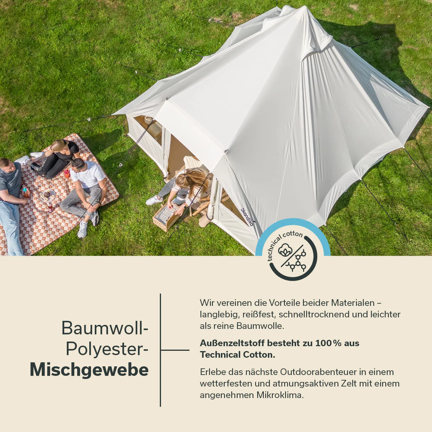 Zelt aus hellem Material steht auf grüner Wiese. Vier Personen sitzen auf einer Decke, entspannen und konsumieren Snacks.