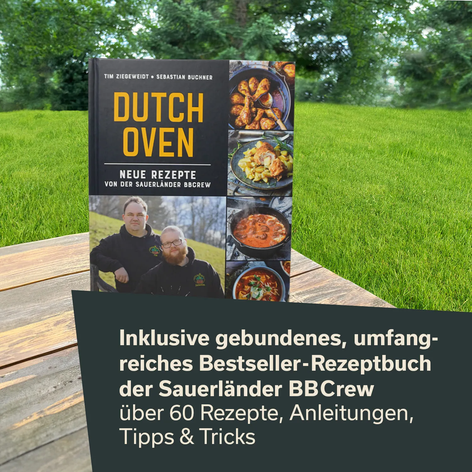 Ein Kochbuch mit dem Titel "DUTCH OVEN" steht auf einem Holztisch. Es zeigt Rezepte und Bilder von Gerichten sowie Informationen über den Inhalt. Im Hintergrund sind eine grüne Wiese und Bäume sichtbar.