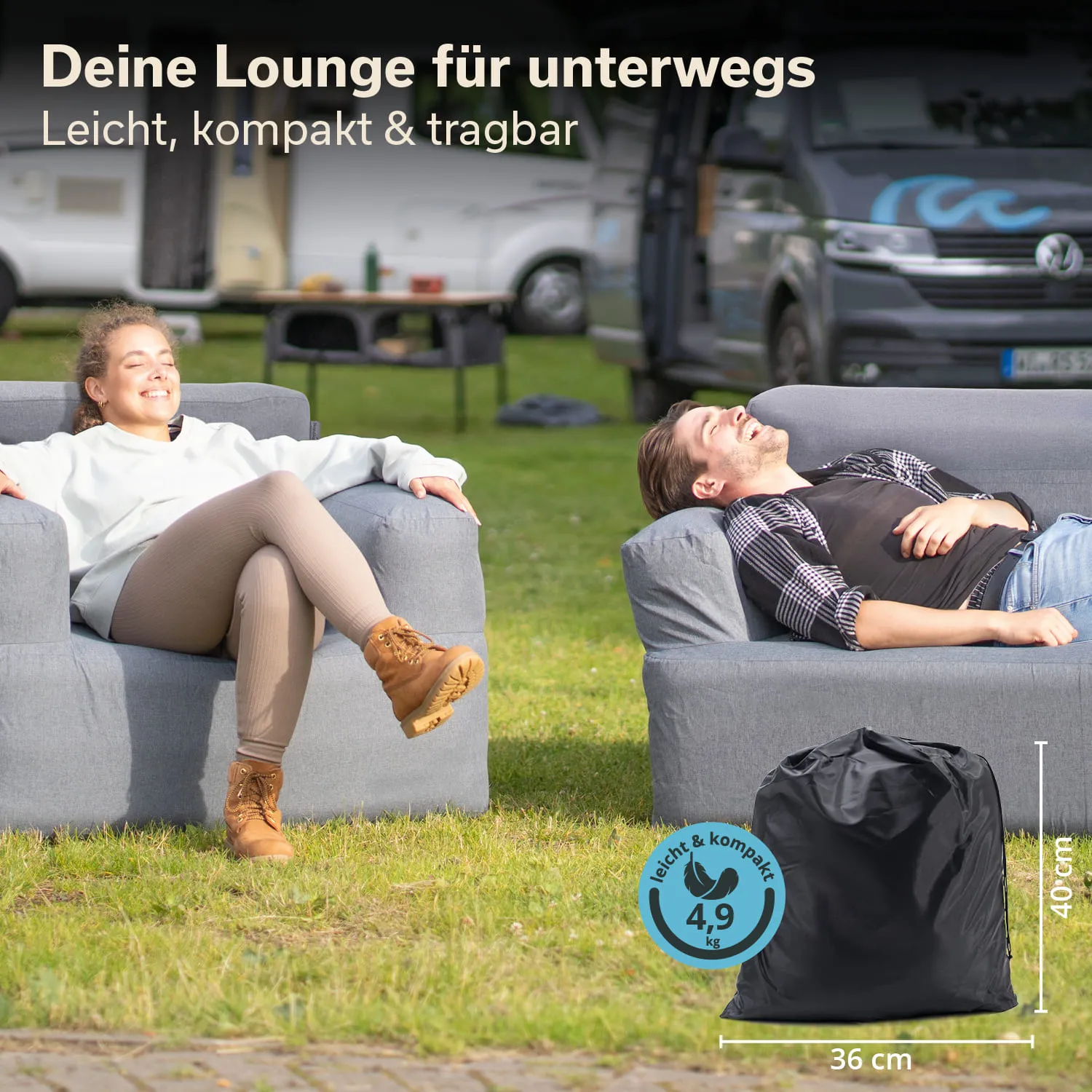 Zwei Personen sitzen entspannt auf grauen Sofas auf einer Wiese. Im Hintergrund sind Wohnmobile sichtbar. Ein schwarzer Sack mit Maßen und Gewicht steht im Vordergrund.