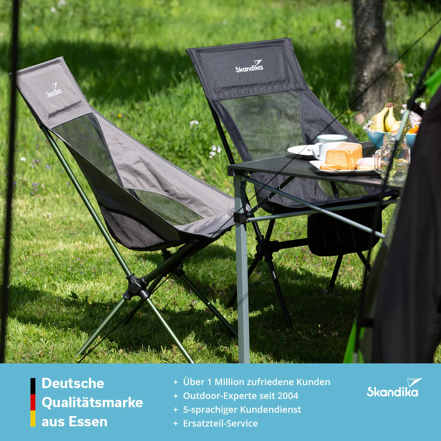 Zwei Klappstühle stehen auf grünem Gras neben einem Tisch, der mit Lebensmitteln und Getränken gedeckt ist.