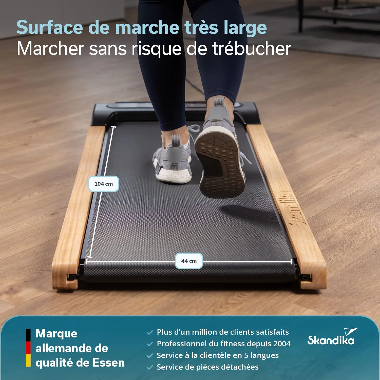 Lauffläche eines Laufbands mit einer Person, die darauf geht. Maße der Lauffläche sind angegeben: 104 cm und 44 cm. Holzrahmen sichtbar.