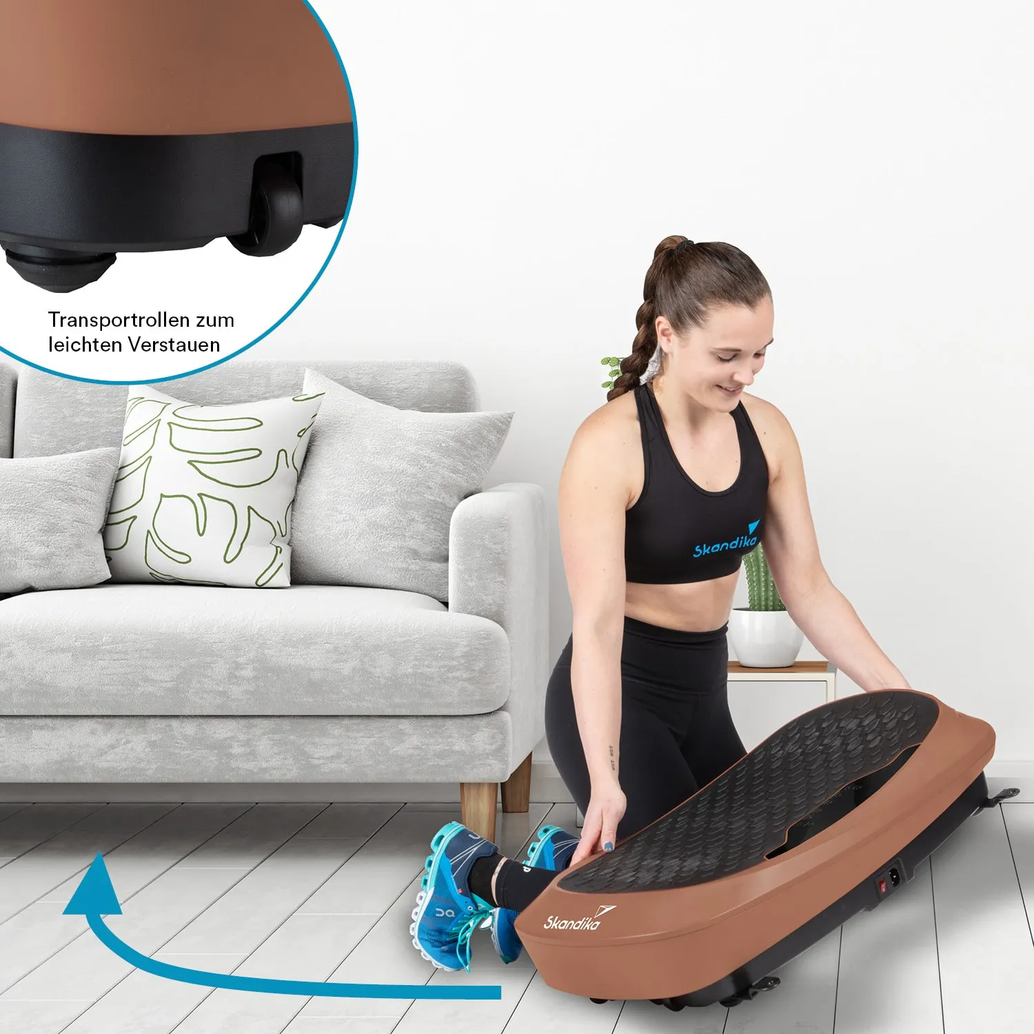 Eine Person kniet vor einem Möbelstück und hält ein Fitnessgerät in der Hand. Der Hintergrund zeigt ein graues Sofa mit Kissen und einem kleinen Pflanzenbehälter.