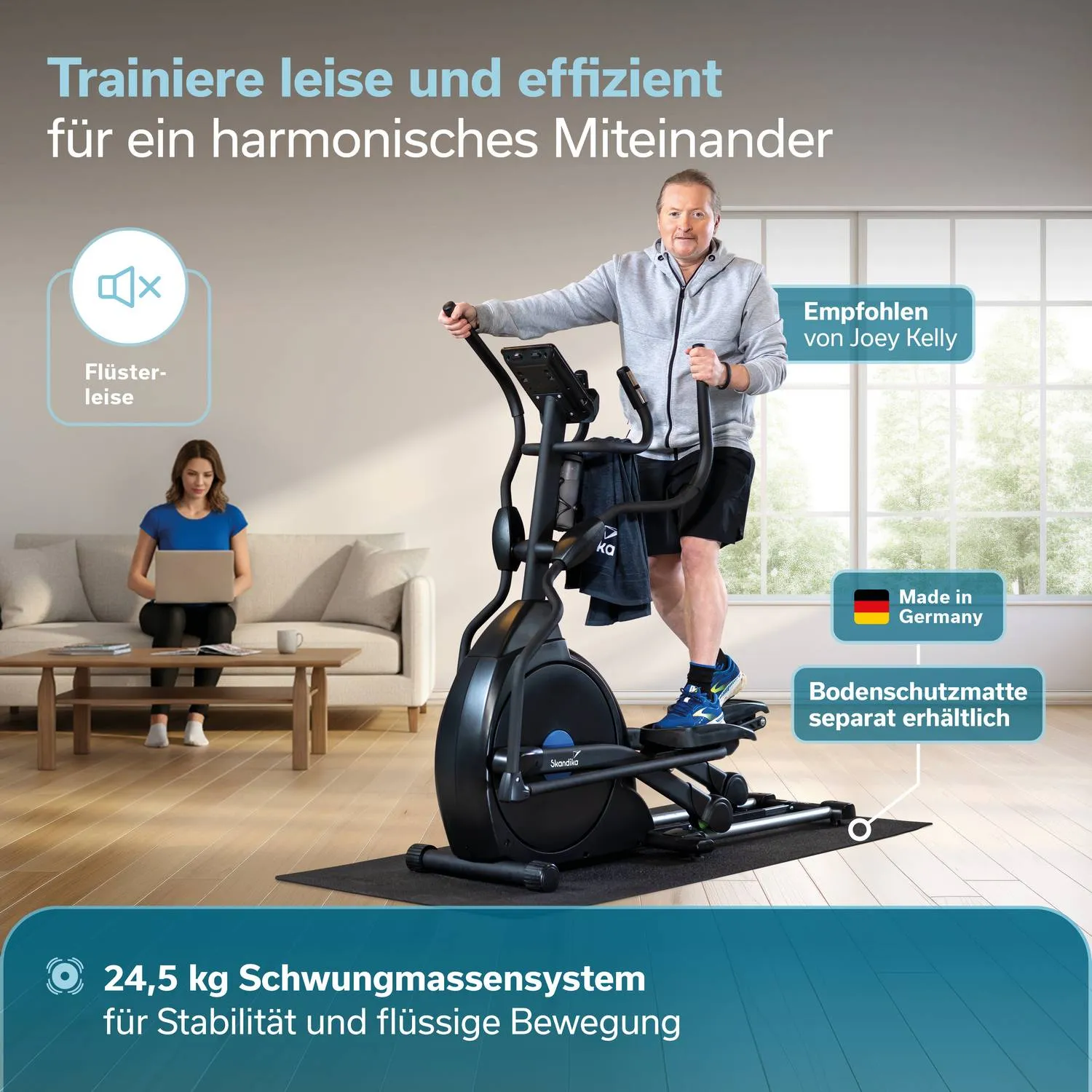 Mann auf einem Crosstrainer in Fitnesskleidung, blickt nach vorne. Frau sitzt mit Laptop auf einem Sofa. Helle Innenraumgestaltung.