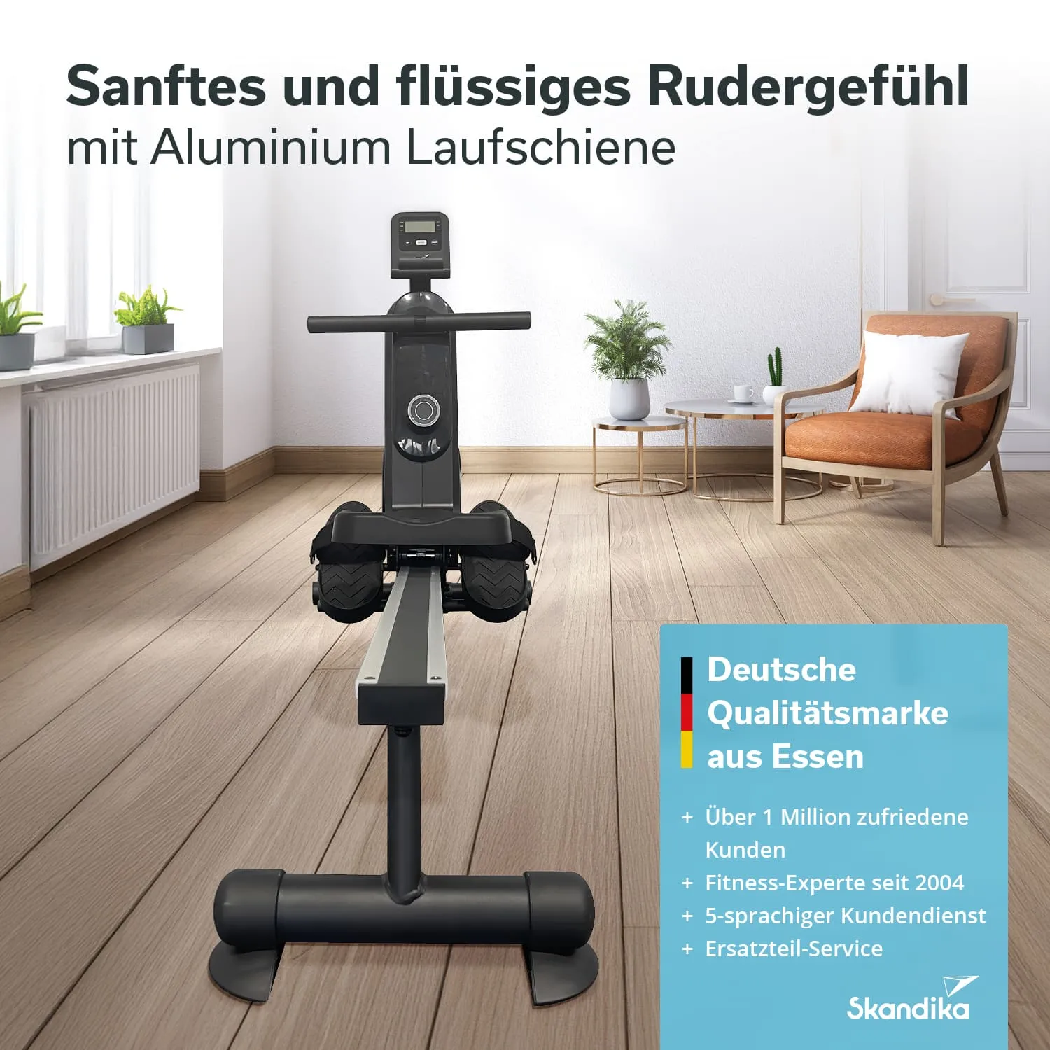 Rudergerät mit Aluminium-Laufschiene auf einem Holzboden in einem hellen Raum. Möbel und Pflanzen im Hintergrund.
