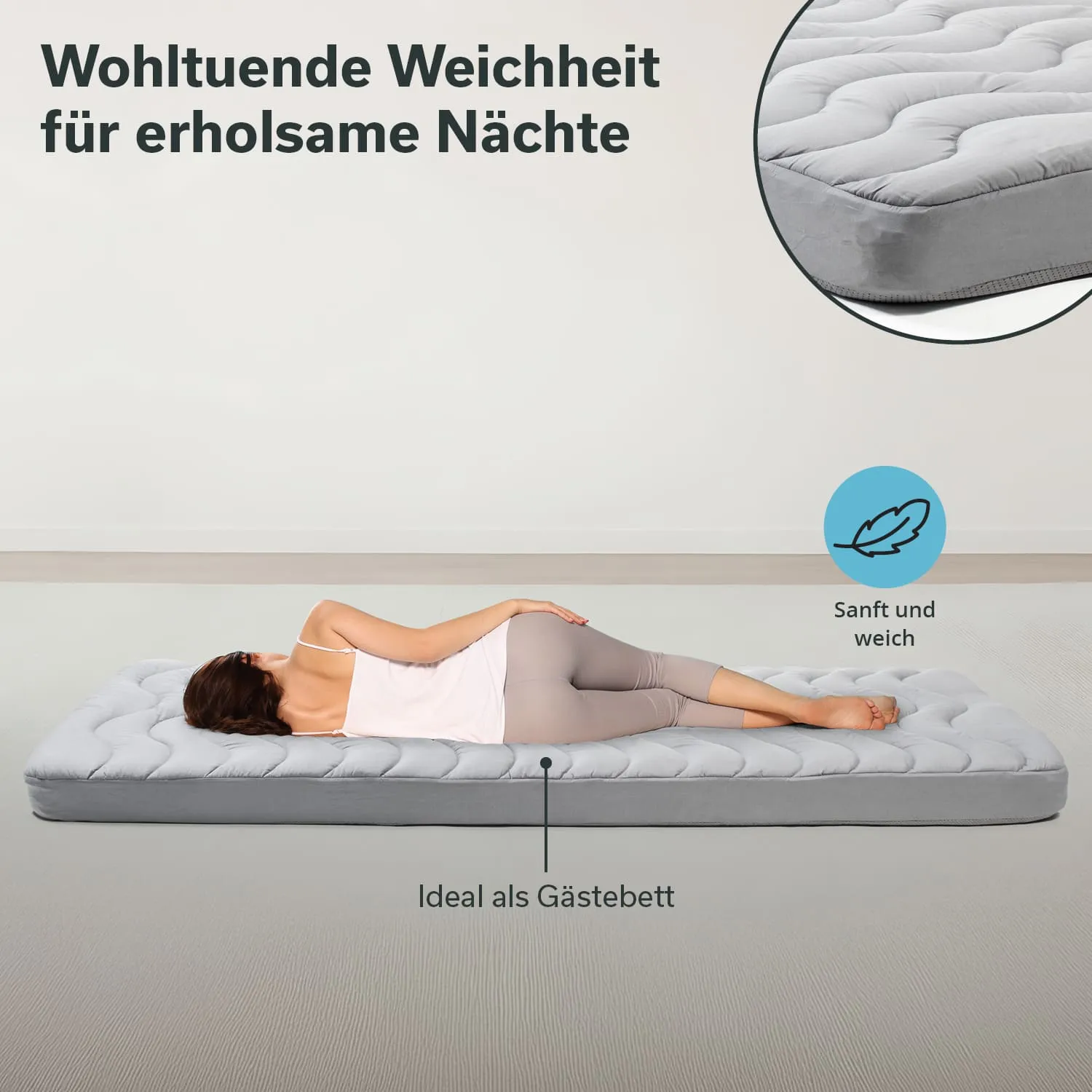 Graue Matratze liegt auf einem hellen Boden. Person liegt seitlich darauf, trägt helle Kleidung. Überlagerter Text beschreibt die Matratze.