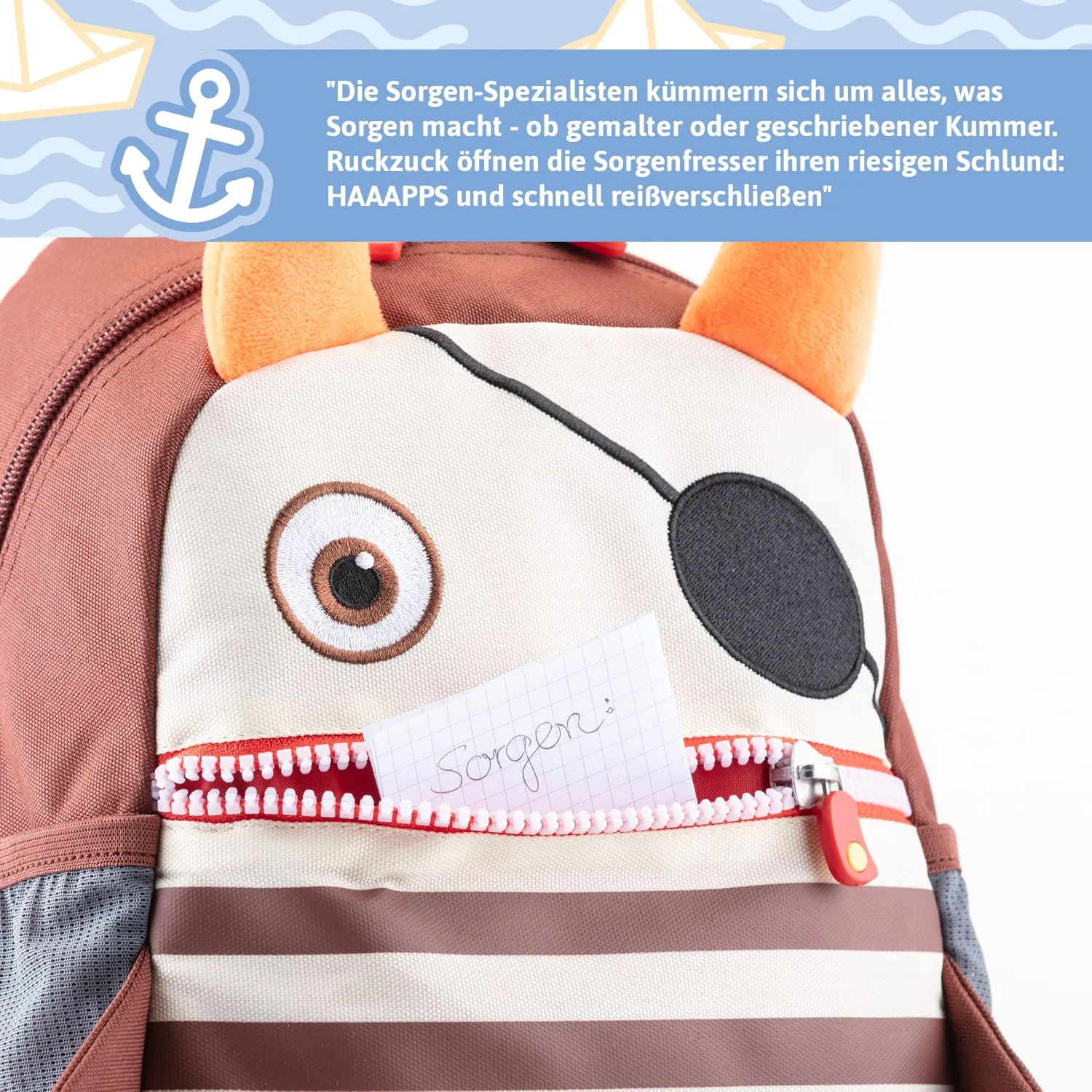 Kinderrucksack mit Tiermotiv, darunter ein Zettel mit der Aufschrift „Sorgen:“ in der offenen Tasche.
