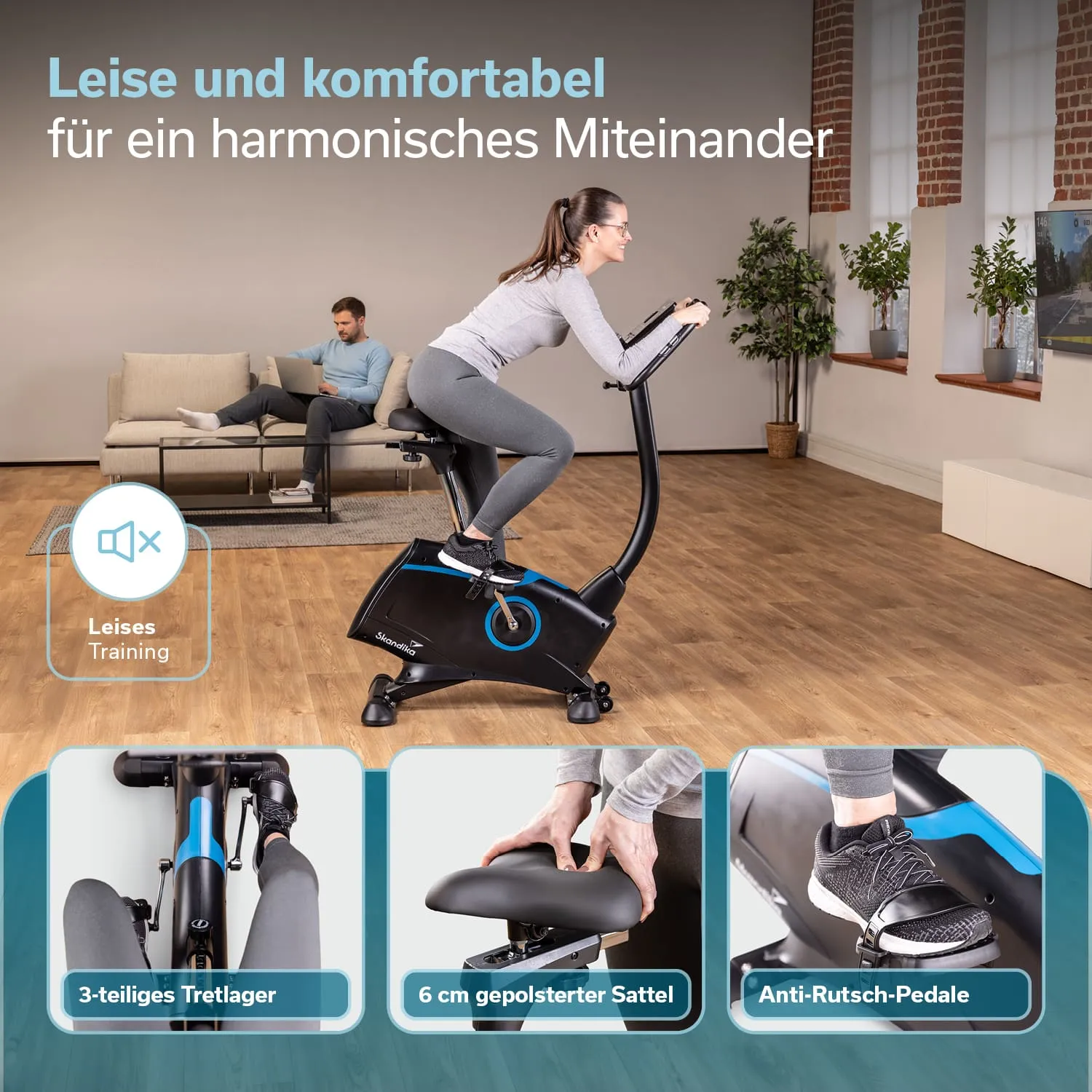 Ein Heimfahrrad in schwarz mit blauen Elementen steht in einem Wohnzimmer. Im Hintergrund sind ein Sofa und ein Beistelltisch sichtbar.