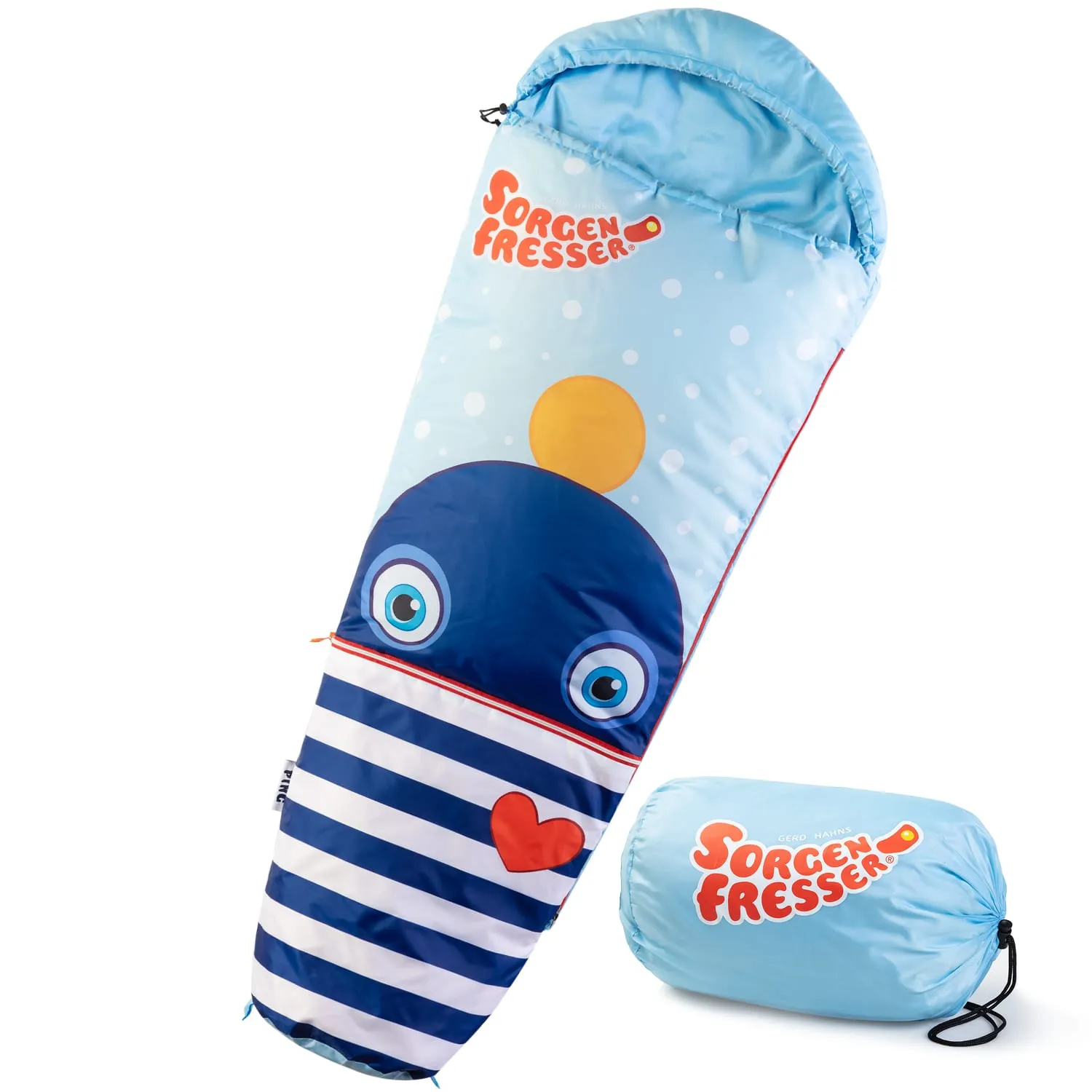 Schlafsack in Form eines blauen Wals mit Streifenmuster und großen Augen. Neben dem Schlafsack ein zusammengerolltes Transportpaket.