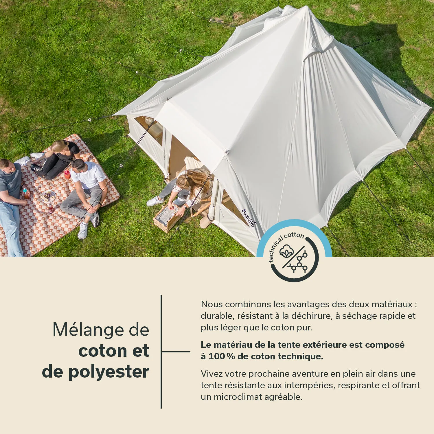 Zelt aus hellem Material auf grünem Gras, mit drei Personen, die auf einer Decke sitzen und sich unterhalten.