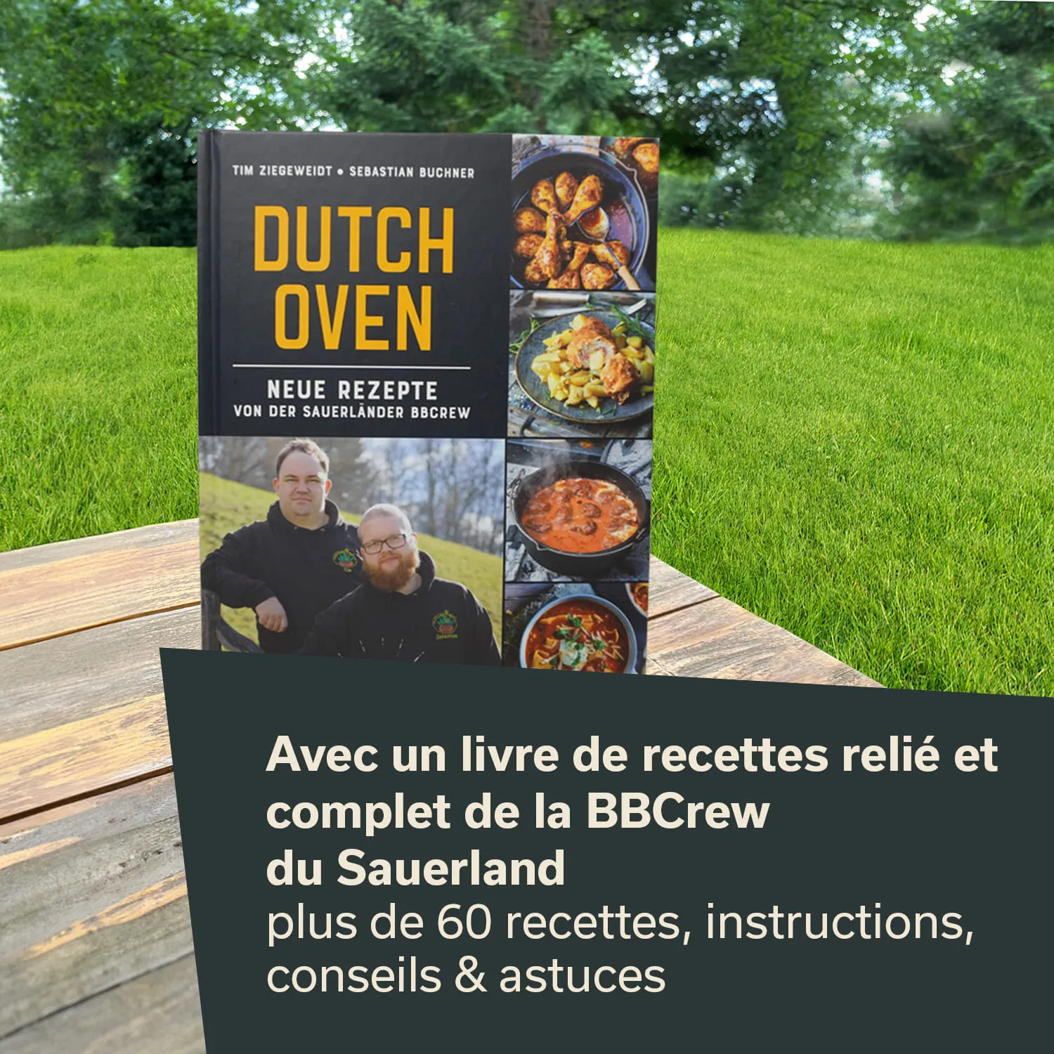 Ein Kochbuch mit dem Titel "Dutch Oven" steht auf einem Holztisch. Im Hintergrund sind ein Rasen und Bäume sichtbar.