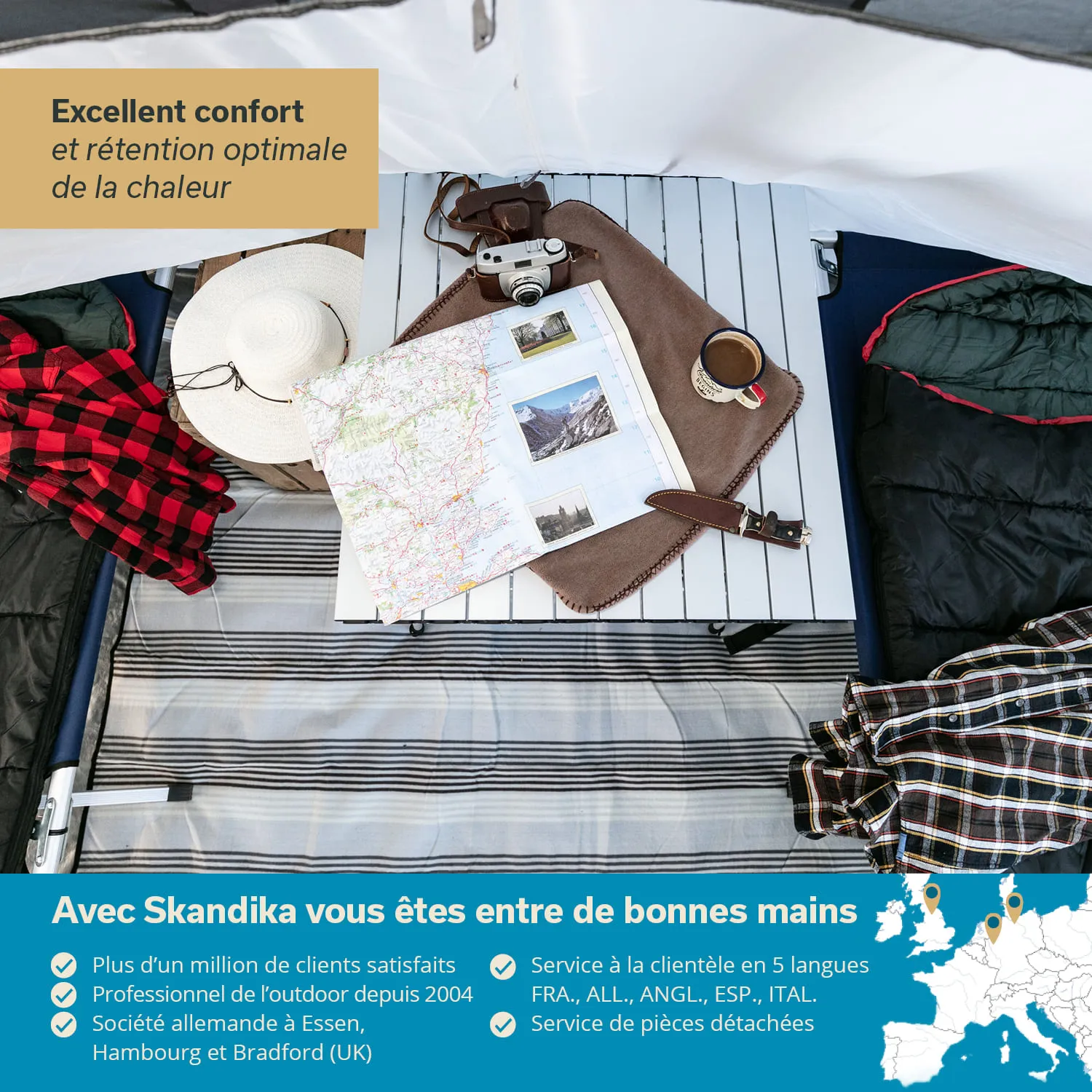 Campingausrüstung auf einer Liege: Karte, Kamera, Tasse, Sonnenhut und Decke auf einem gestreiften Untergrund.