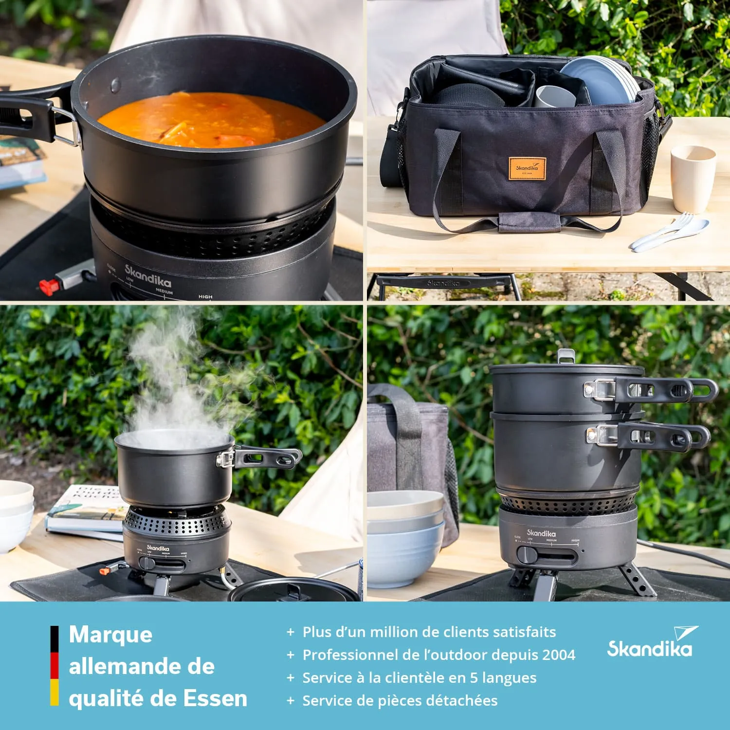 Ein Kochgerät mit einem Topf, der eine Suppe enthält, steht auf einem Tisch. Daneben eine Tragetasche mit Geschirr und Besteck. Dampf steigt aus einem weiteren Topf auf. Hintergrund mit grünen Pflanzen.