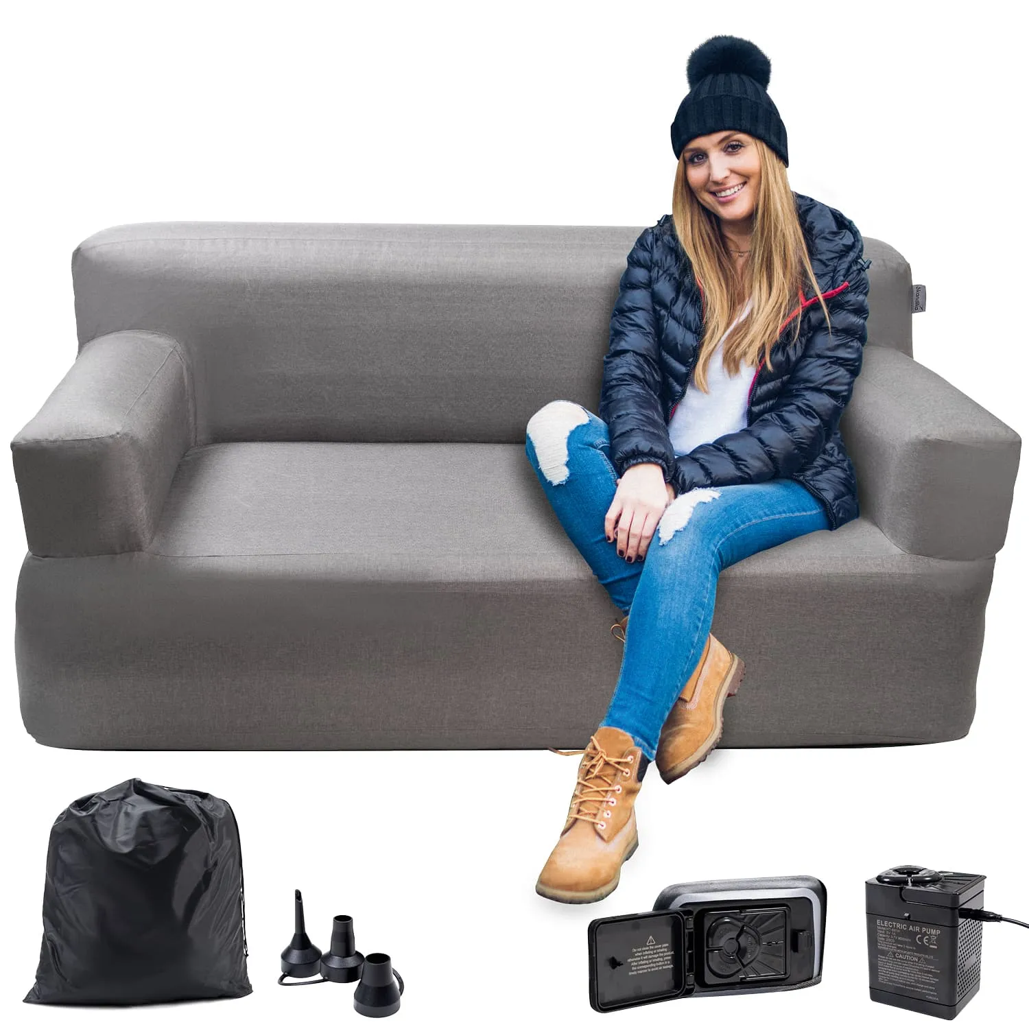 Graue Couch mit einer Person, die darauf sitzt, umgeben von einem schwarzen Sack, Aufblasspitzen und einer elektrischen Pumpe.