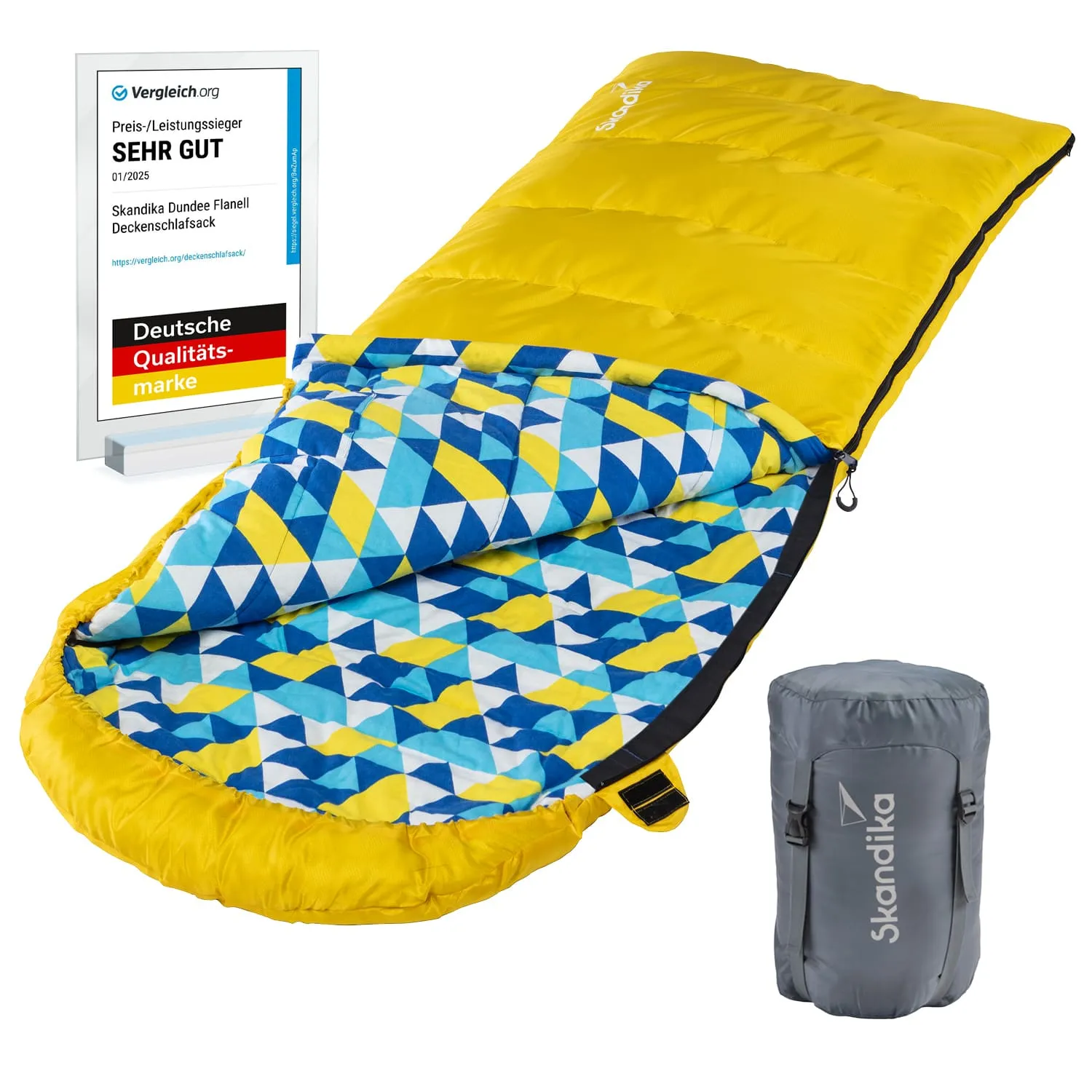 Gelber Schlafsack mit geometrischem Innenmuster in Blau und Gelb, daneben ein grauer Aufbewahrungssack und ein Bewertungsschild.