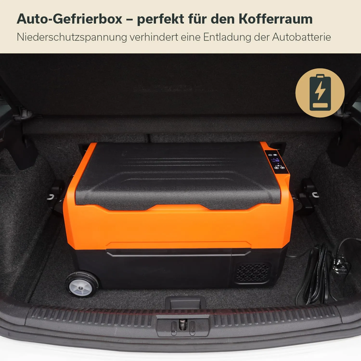 Eine orangefarbene Auto-Gefrierbox steht im Kofferraum eines Autos. Daneben befinden sich Kabel und Anschlüsse. Die Innenausstattung ist dunkel.